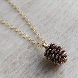 Brass pine cone charm necklace with a gold plated chain.
