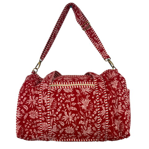 Red duffle bag with white floral pattern on a white background