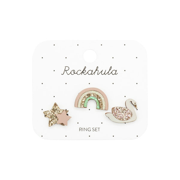 Set of three decorative rings with a star, rainbow, and swan design on a white card.