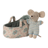 baby mouse next to fabric carry cot on a white background