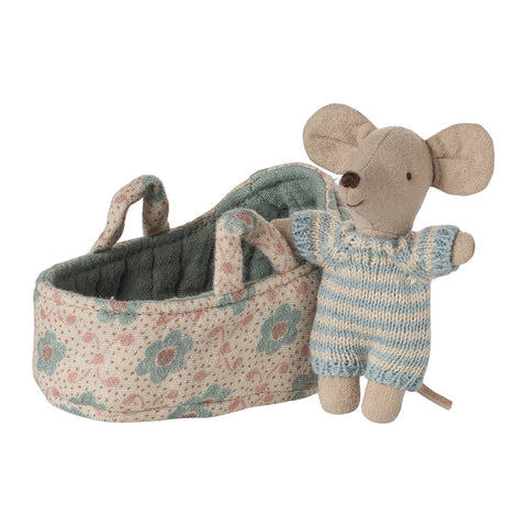 baby mouse next to fabric carry cot on a white background
