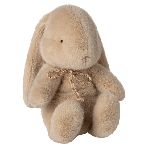 plush bunny with bow set onto a white back.
