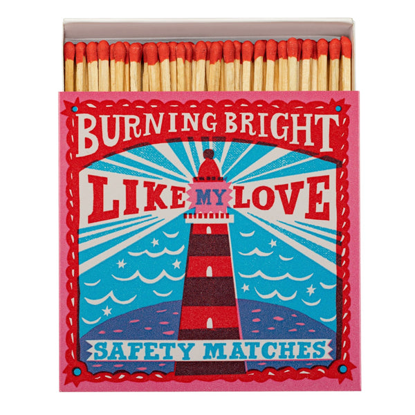 Matches box with a lighthouse design in bright reds and blues with the text Burning Bright Like My Love Safety Matches.