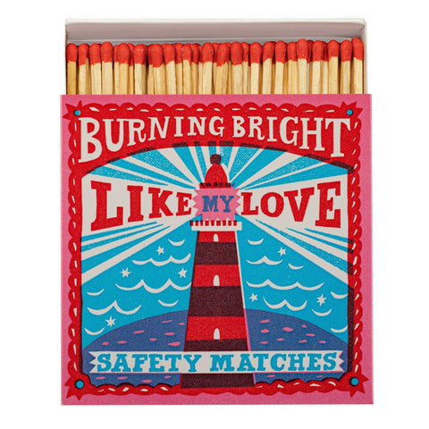Matches box with a lighthouse design in bright reds and blues with the text Burning Bright Like My Love Safety Matches.