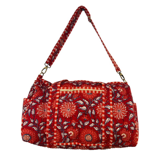 Red floral patterned duffle bag on a white background