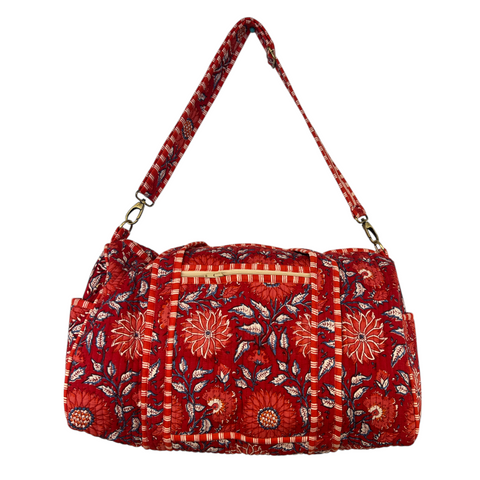 Red floral patterned duffle bag on a white background