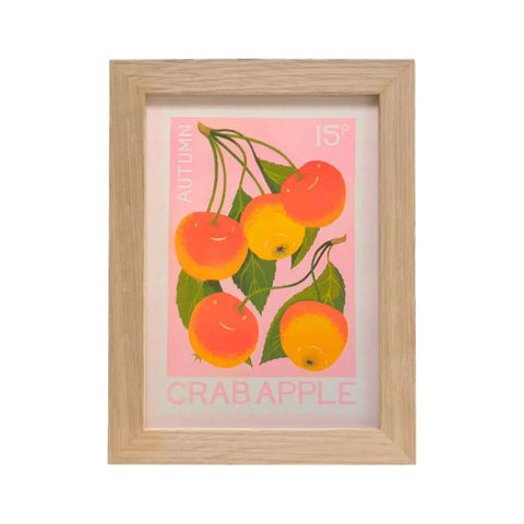 A framed art print featuring a vintage-style illustration of crab apples in autumn colors, set in a light natural wood frame against a white background.