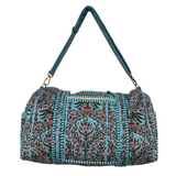 Floral blue patterned duffle bag with a blue strap on a white background