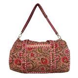 Floral patterned duffel bag with a strap on a white background