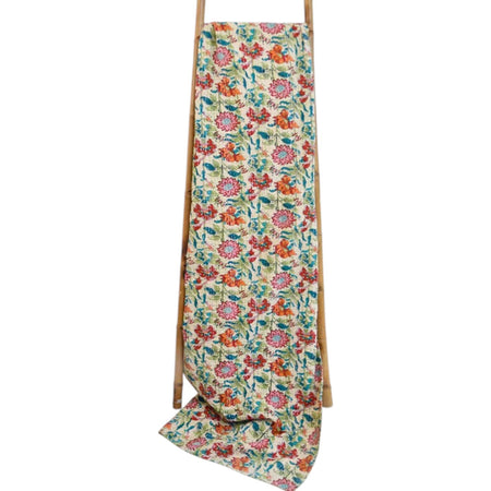 Floral patterned towel draped over a wooden ladder on a white background