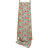 Floral patterned towel draped over a wooden ladder on a white background