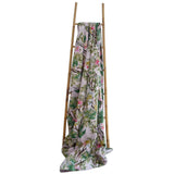 Floral-patterned blanket draped over a wooden ladder on a white background