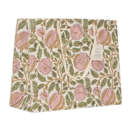 A square fabric gift bag featuring a vintage floral pattern with pink flowers and green leaves on an off-white background. A small paper brand tag is attached to the right side.