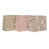 Three decorative paper gift bags with floral and botanical patterns in soft pink, sage green, and beige tones, arranged side by side on a plain white background.