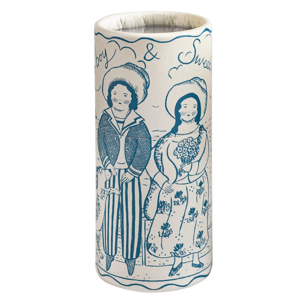 A tall cylindrical tube with a white base and blue hand-painted illustration of two people standing side by side, with the words 'Boy & Sweet' written above them.