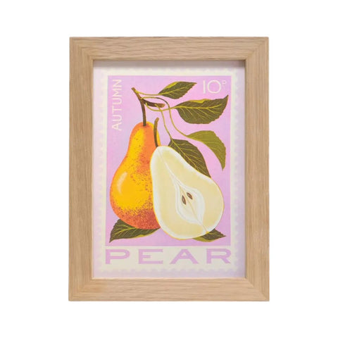 A framed art print featuring an autumn pear illustration with a whole and halved pear on a light pink background, enclosed in a natural wood frame.