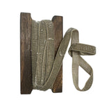 Spool of pewter coloured ribbon with wooden reel on a white background