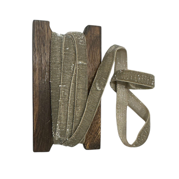 Spool of pewter coloured ribbon with wooden reel on a white background