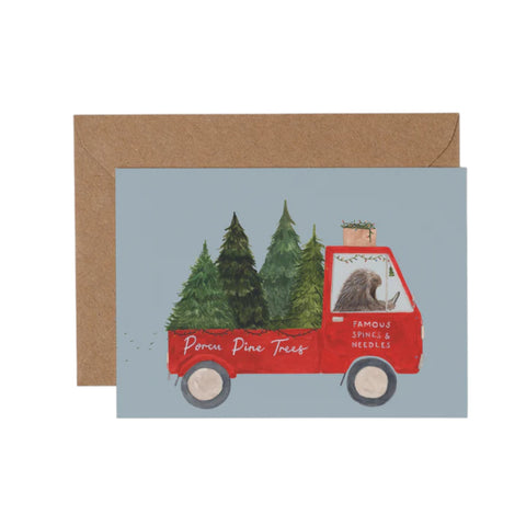 Card with a red truck carrying trees and a brown envelope on a white background