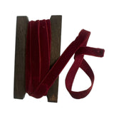 Spool of red velvet ribbon on a white background