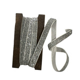 Silver glitter ribbon on a wooden spool on a white background