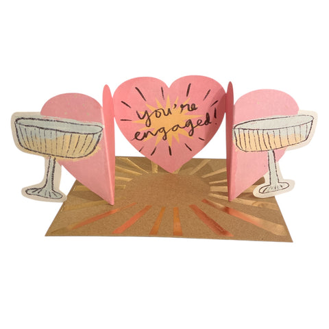 a die cut card featuring two clinking champagne glasses