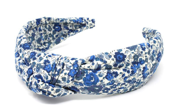 Floral pattern padded headband with twisted fabric knot.